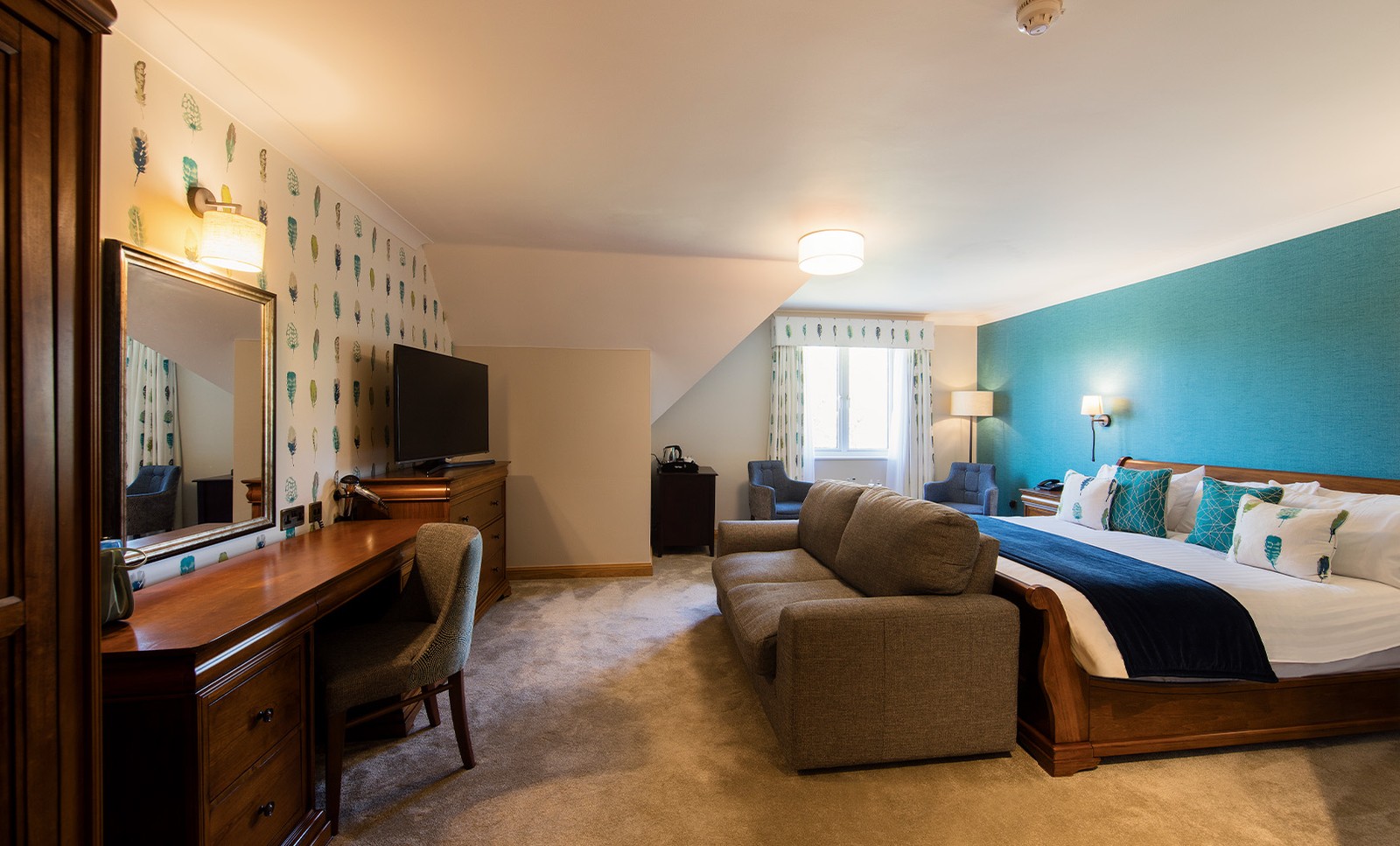 A large room found in the Royale rooms with bed and additional seating.