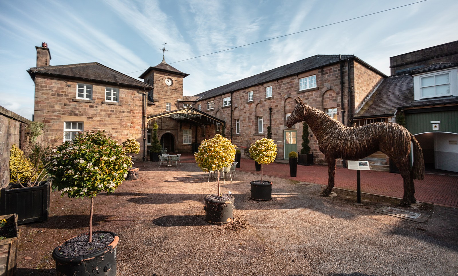 In the courtyard, a whimsical horse statue stands proudly among the shrubs - another unique little corner just waiting to be explored.