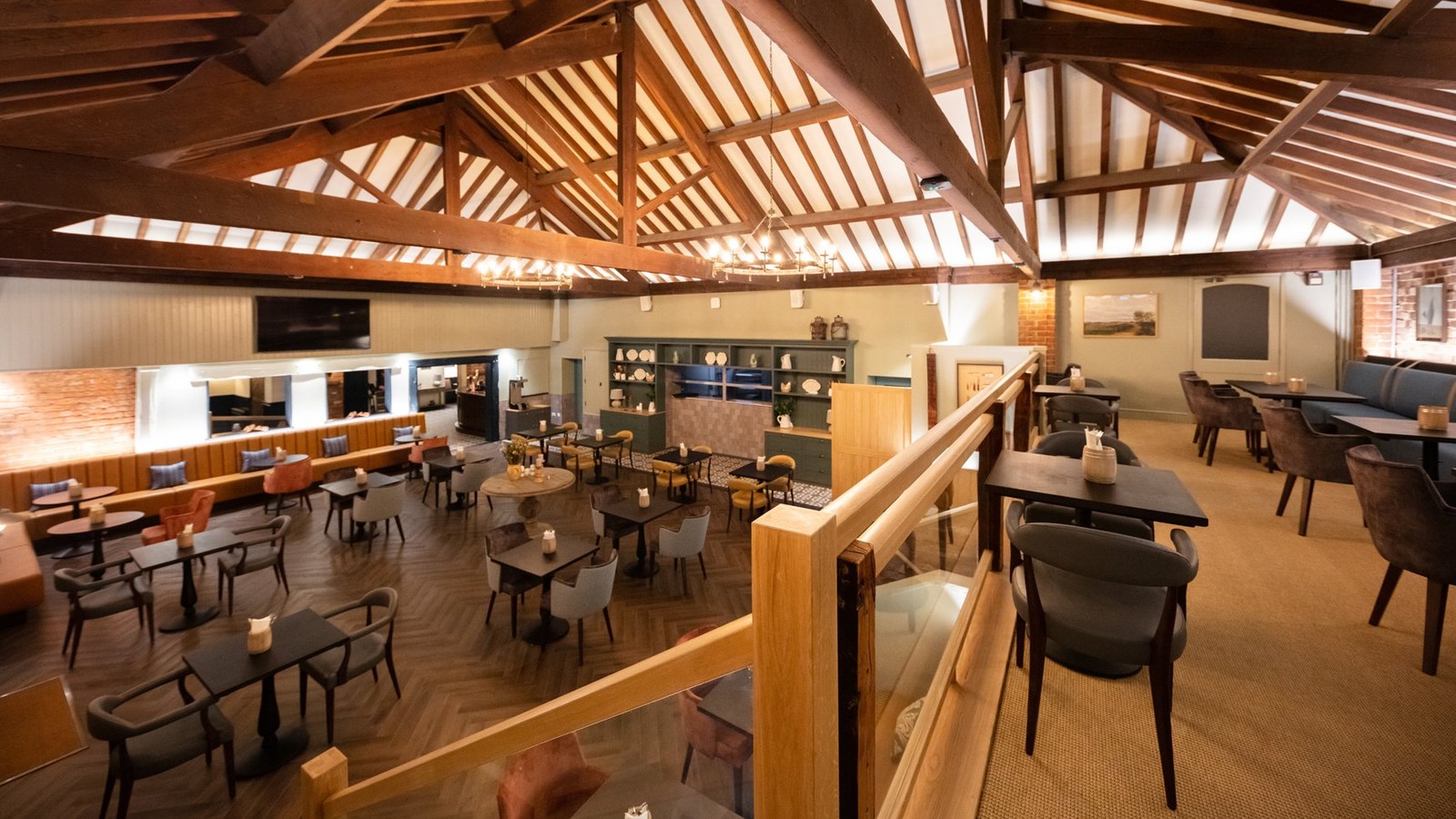 Inside The Cheshire Barn restaurant, two levels of dinning areas with exposed beams on the ceiling.