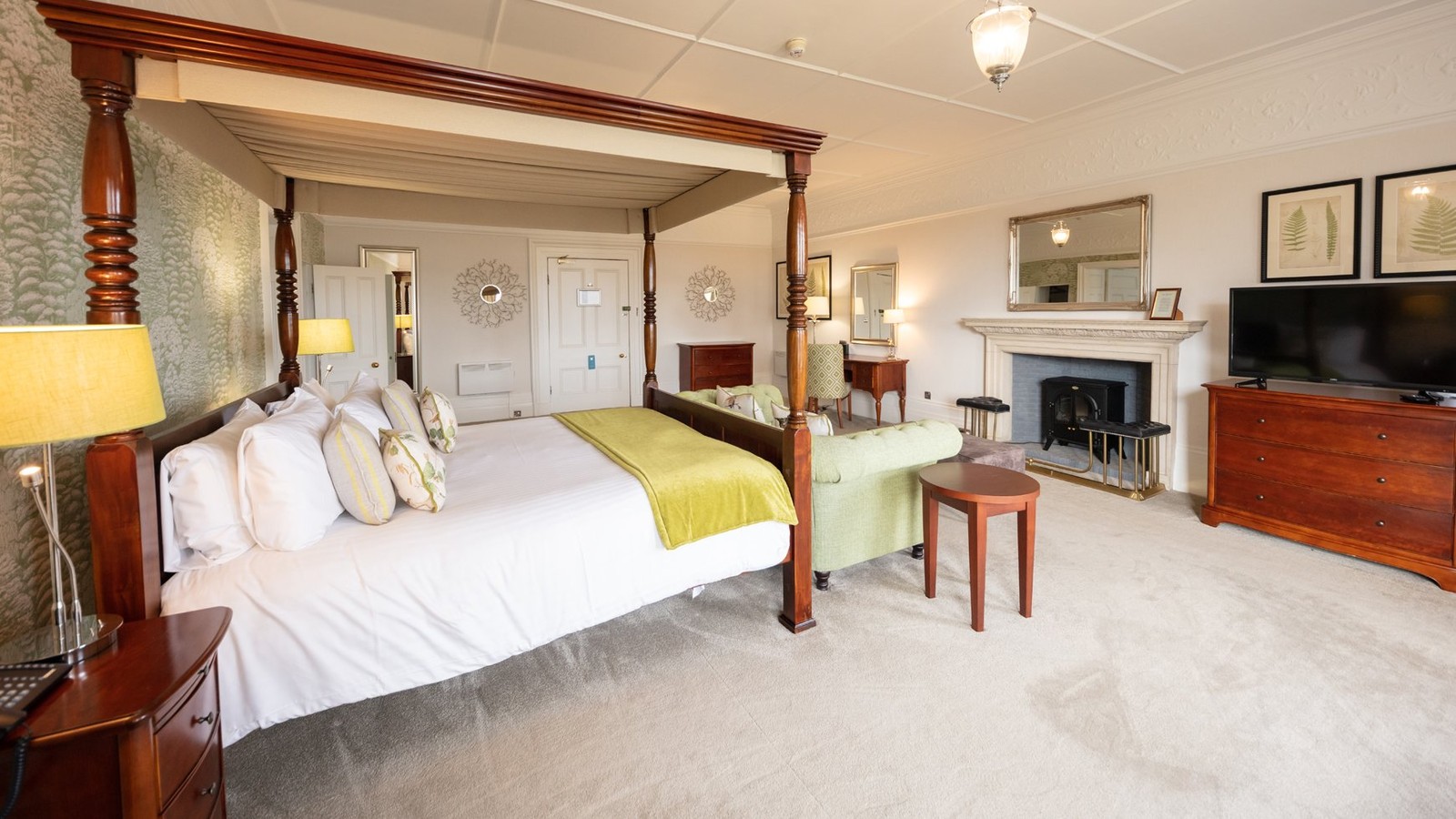 A historic room in the main building featuring a large four poster bed and ample additional seating.