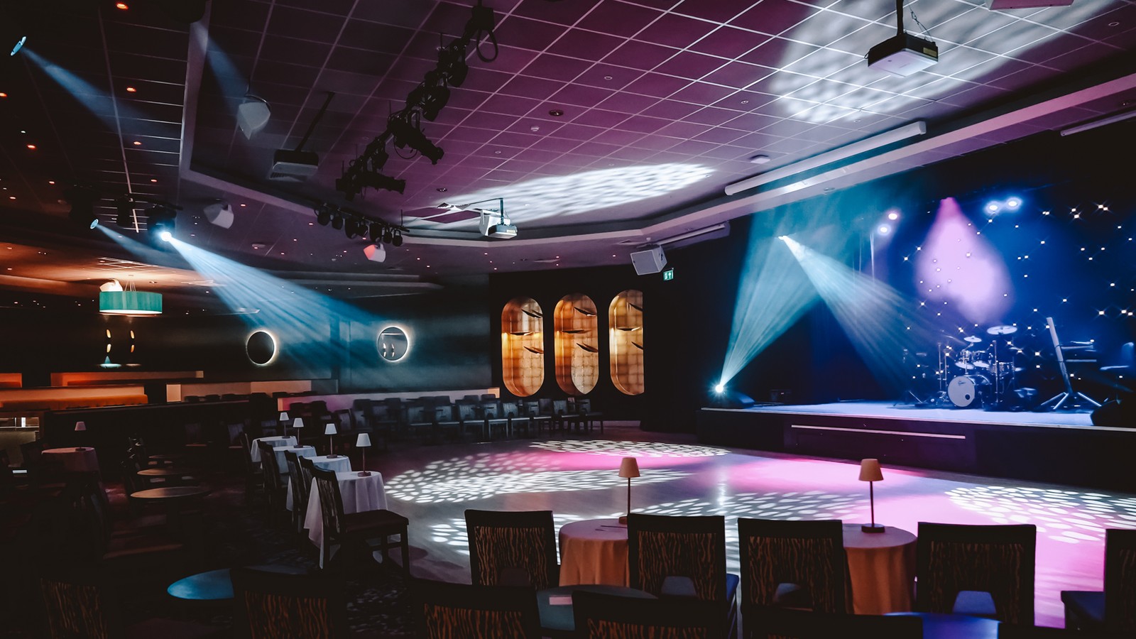 The late lounge entertainment venue with bright lighting and a large stage with comfortable seating surrounded.