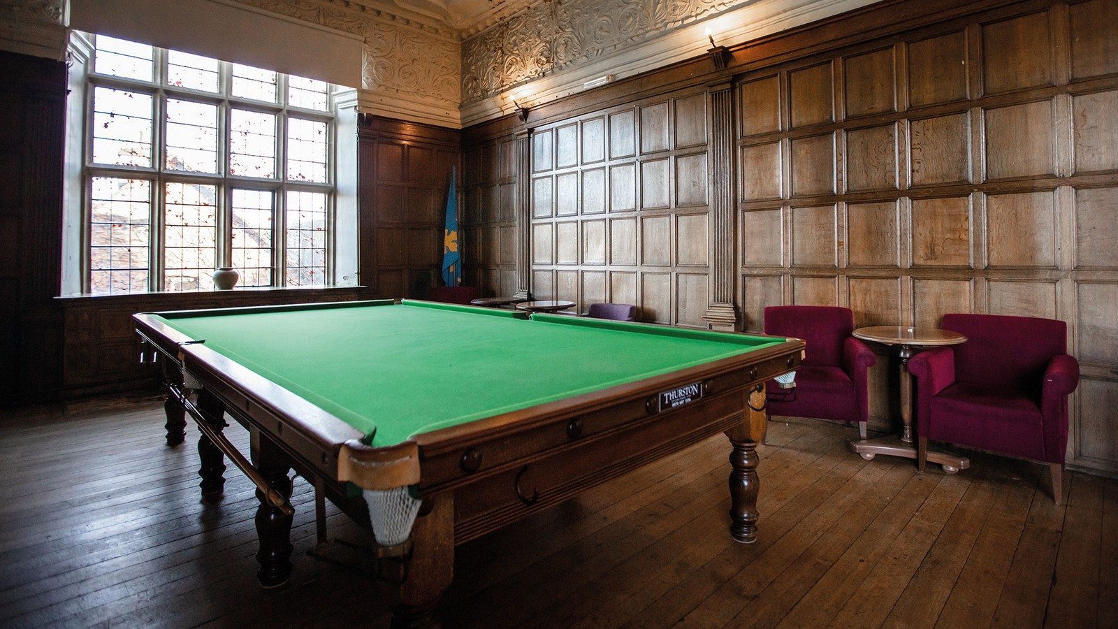 The snooker room inside the old house building with additional seating.
