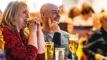 A couple enjoying a drink at a table at the BBC History Magazine Weekend at a Warner Hotel.
