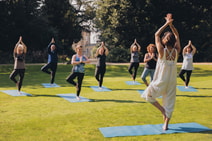 Group of people enjoying a guided meditation in the sun