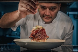 A chef putting the finishing touches on a dish