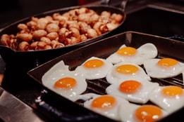 Fried eggs and mushrooms on a hot buffet counter