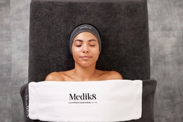 medik8 branded towel on a women getting a massage