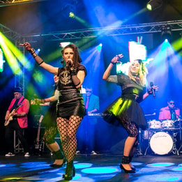 Immerse yourself in the electrifying 80s Explosion at Warner Hotels as the band and singers on stage captivate the audience.