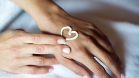 Close up of a person's hand with a heart drawn with cream