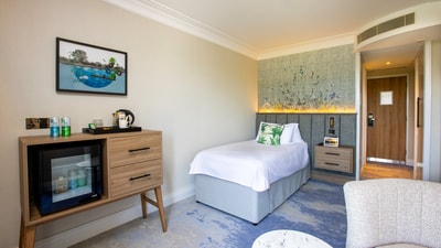 A cosy single bed in a large room