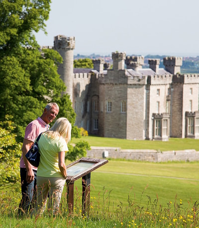 Guests at Bodelwyddan Castle exploring the grounds, with the castle in the background