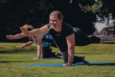 Group of people enjoying a guided yoga session in the sun