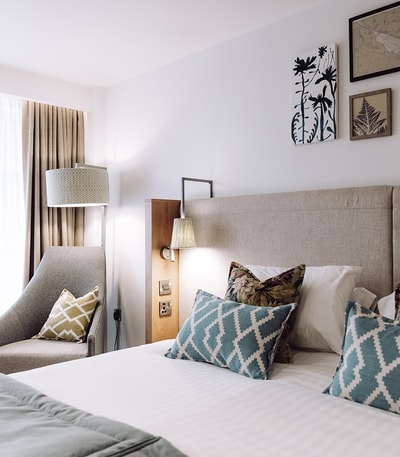 A Deluxe room at Heythrop Park showing the bed and a chair in the room