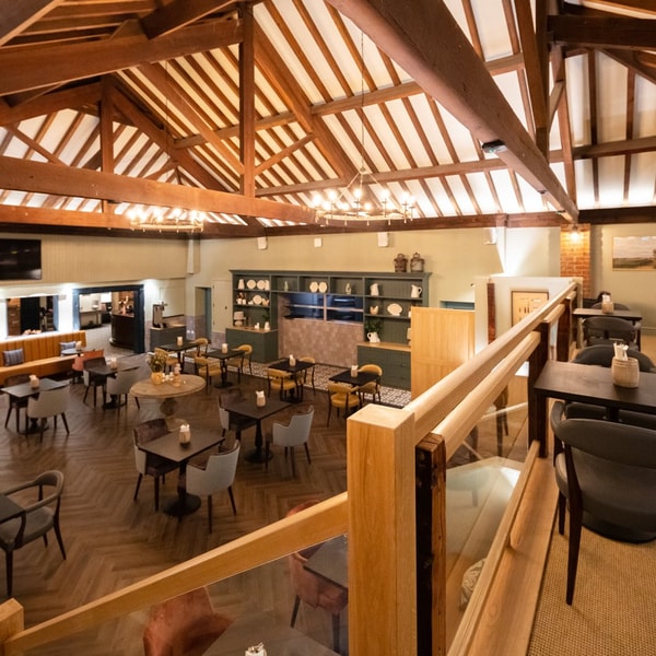Inside The Cheshire Barn restaurant, two levels of dinning areas with exposed beams on the ceiling.