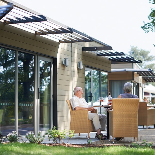 Outside view of the garden lodges with comfortable seating surrounded by nature.