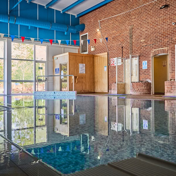 The large indoor pool with big windows offering bright natural light.