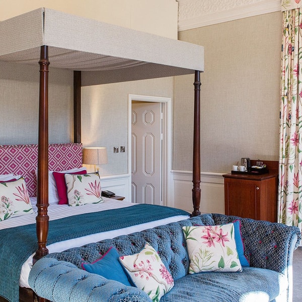 A Historic room in the main house with a four-poster bed and large windows with additional seating areas.