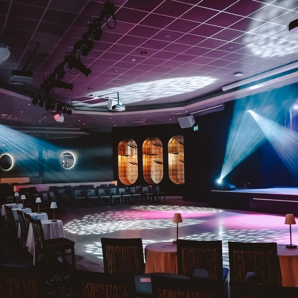 The late lounge entertainment venue with bright lighting and a large stage with comfortable seating surrounded.