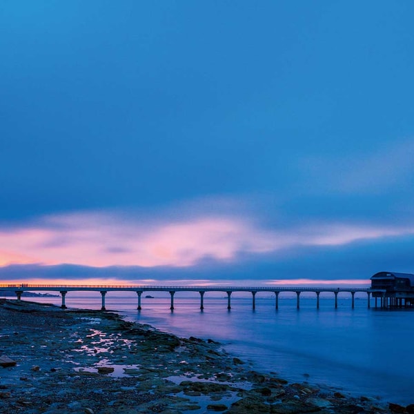 Take a stroll down this long dock, surrounded by the calming waters and the stunning hues of sunset.