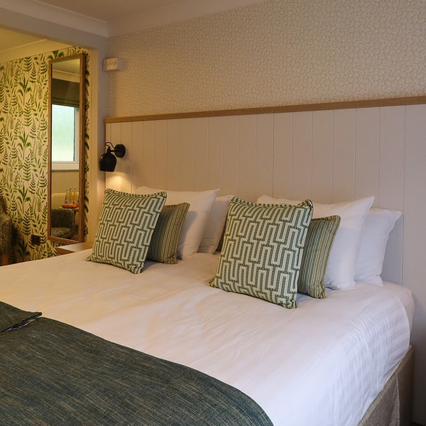 A comfortable Premier chalet room at Gunton Hall featuring a comfortable bed and seating area.