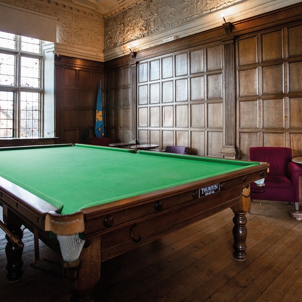 The snooker room inside the old house building with additional seating.