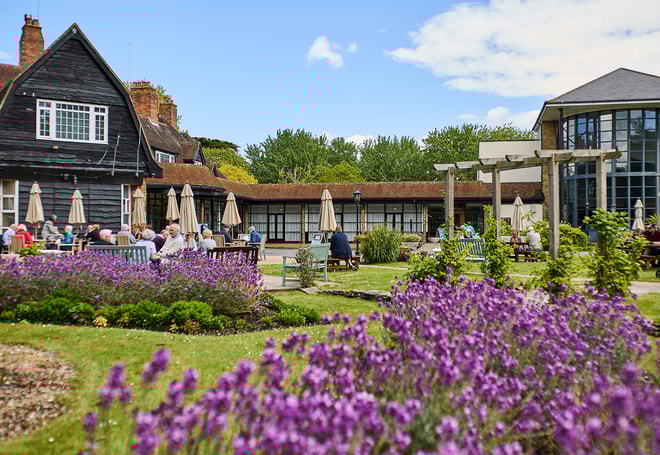 Guests on the terrace at Sinah Warren during the summer months, when the gardens are in bloom