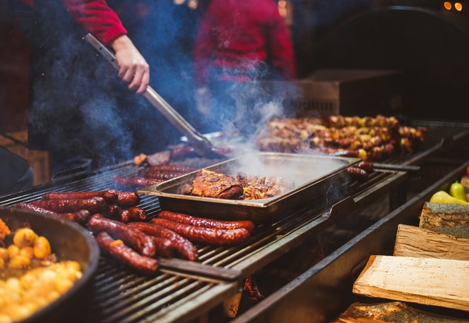 BBQ grill with sausages and other meats being cooked
