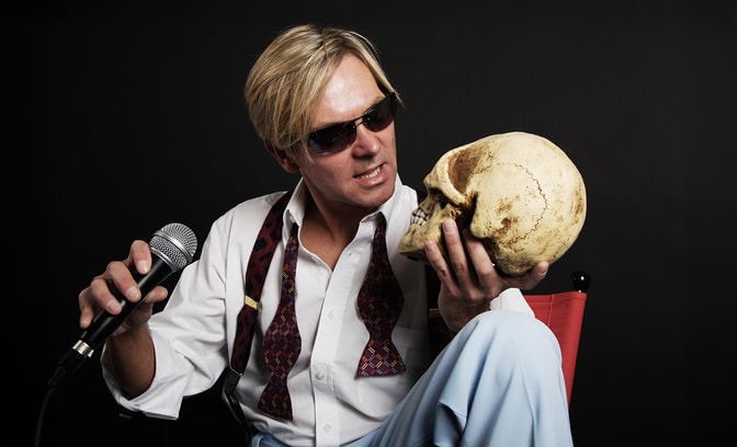 Bootleg Bowie staring at a skull in his hand with interest