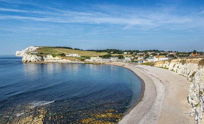 Freshwater Bay on the Isle of Wight, featuring a picturesque shingle and pebble beach framed by dramatic white chalk cliffs.