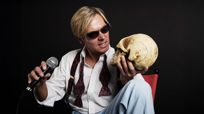 Bootleg Bowie staring at a skull in his hand with interest