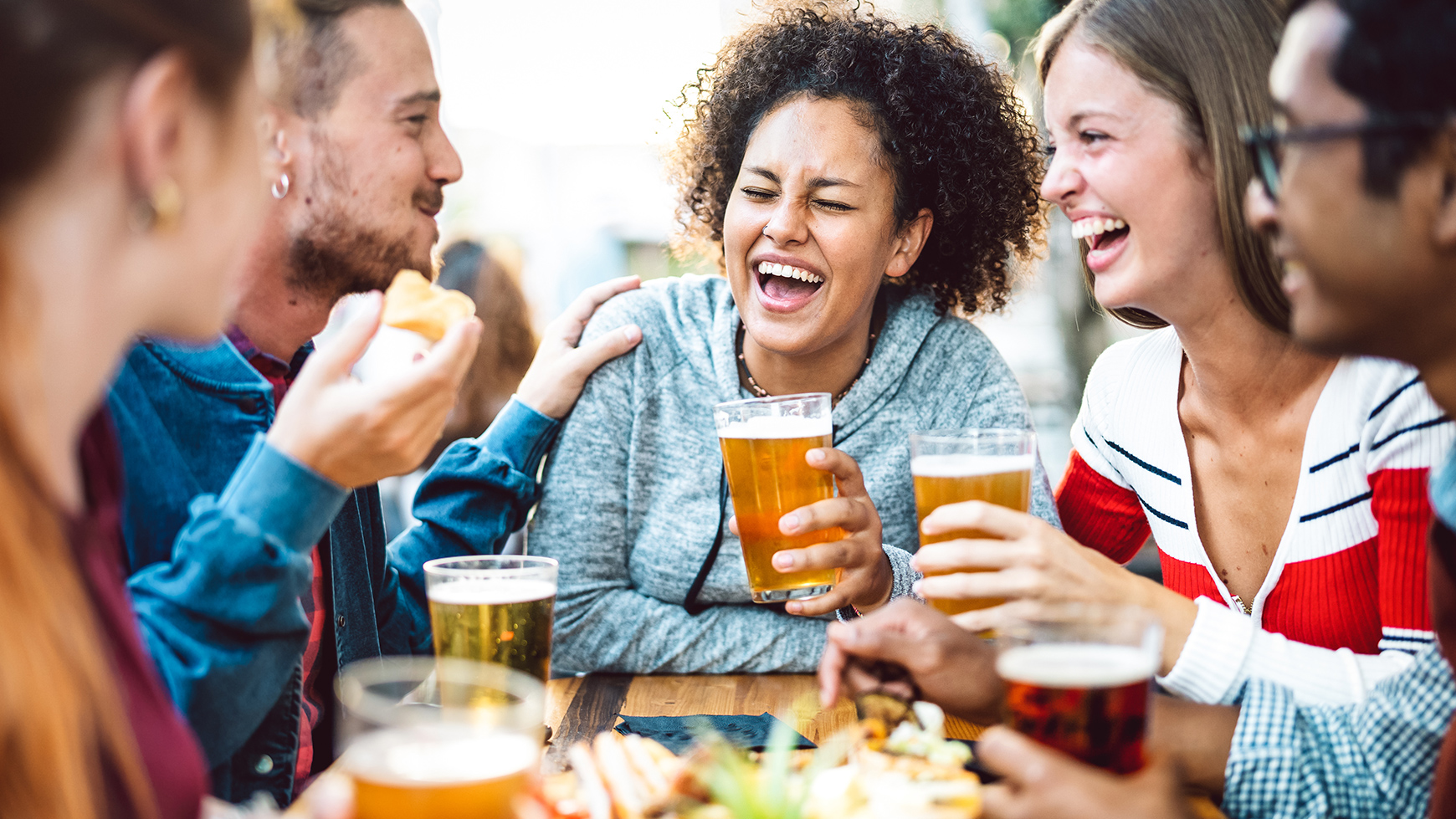 A group of friends eating and drinking at a food festival