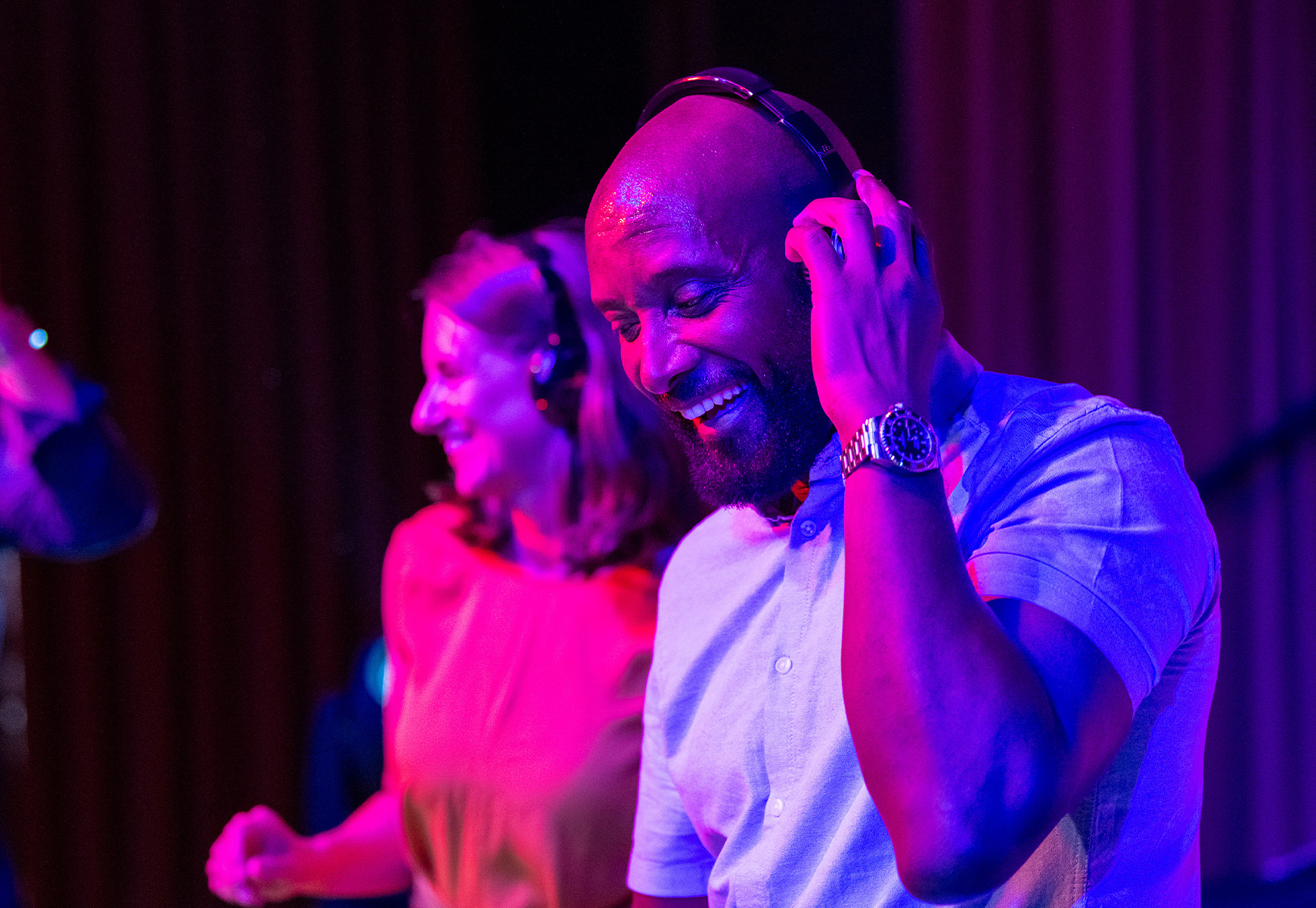 Two guests with headphones smiling during a silent disco