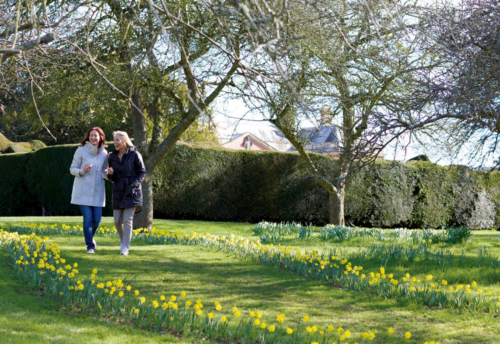 Two guests strolling side by side in the sunshine