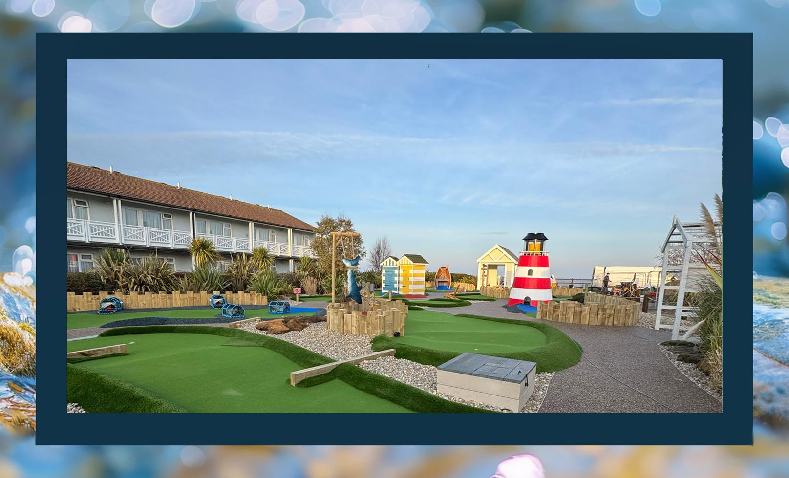 A colorful mini-golf course featuring a striped lighthouse, beach huts, and lush greenery, with playful blue and green pathways.