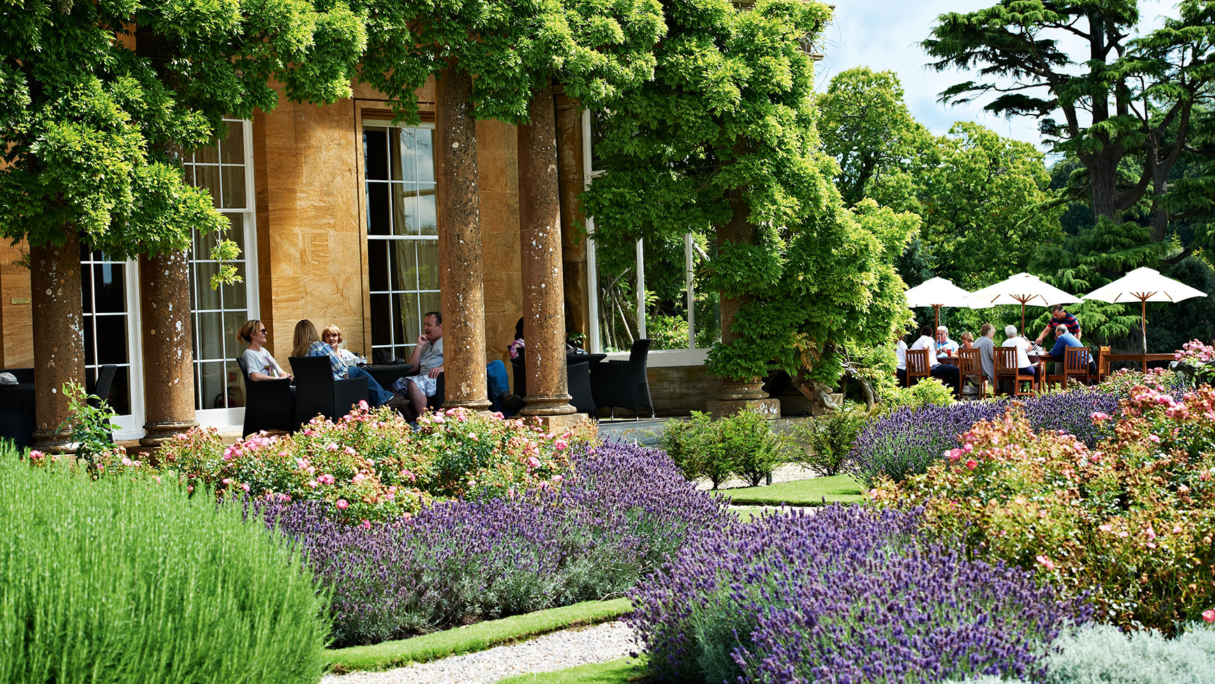 Guests sat on the terrace at Cricket St. Thomas enjoying a relaxed break surrounding by greenery